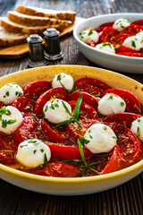 Roasted tomatoes and labneh cheese salad on wooden table