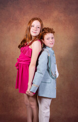 photo shoot in the studio, for red-haired siblings on the day of their communion. Ochre background.
