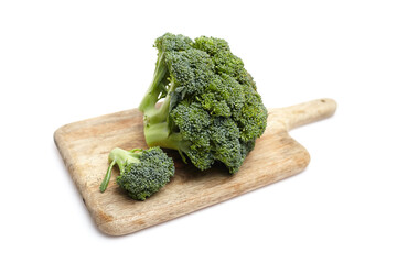 Fresh green broccoli on a wooden cutting board, showcasing vibrant florets and stems, emphasizing...
