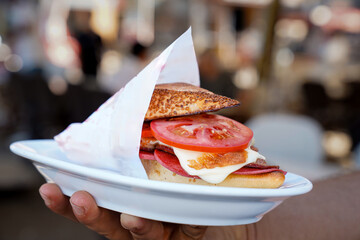 mixed sandwich, the waiter is carrying the mixed sandwich on the plate in his hand	