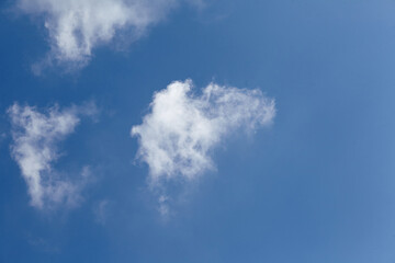 Bright blue sky with fluffy white clouds scattered across the horizon, creating a serene atmosphere and inviting calmness, perfect for backgrounds or nature-themed designs