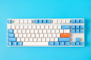 Computer keyboard on blue background. Top view