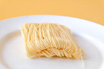 Dried long life noodles on color background.