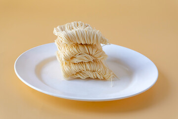 Dried long life noodles on color background.