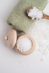 Close-up of magnesium salt flakes. Spa body care and magnesium therapy. White salt, cotton towels, eco-friendly products for home relaxation spa.