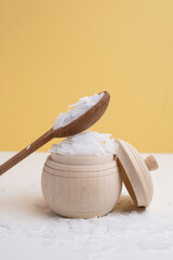 Close-up of magnesium salt flakes. Spa body care and magnesium therapy. White salt, cotton towels,...