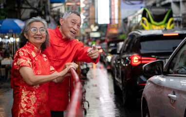 Fototapeta premium A happy senior couple strolls along a Chinatown in Bangkok, Thailand,