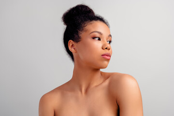 Portrait of a young African-American woman showcasing natural beauty with clear skin, stylish bun...