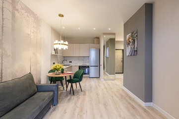 Cozy apartment with open kitchen, dining area, and living space. Modern design with neutral tones and pops of green