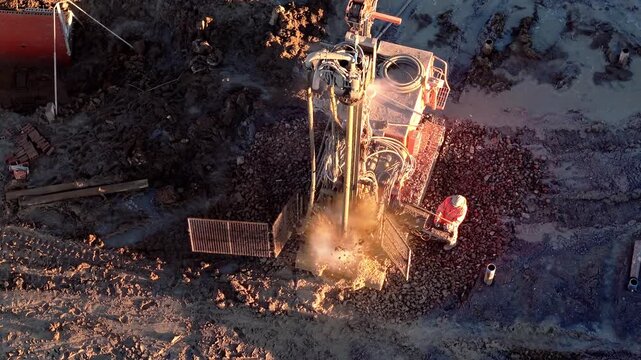 Construction site showcases drilling rig operation in an urban setting during sunrise