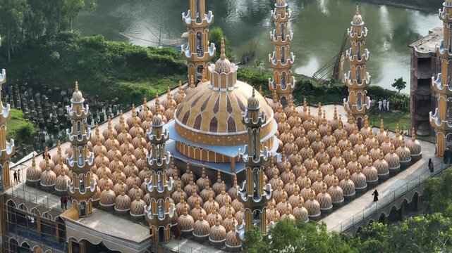 Tangail, Bangladesh - 22 August 2025: Aerial view of the golden domes of the 201 Dome Mosque, a dazzling display of architecture against the lush greenery.