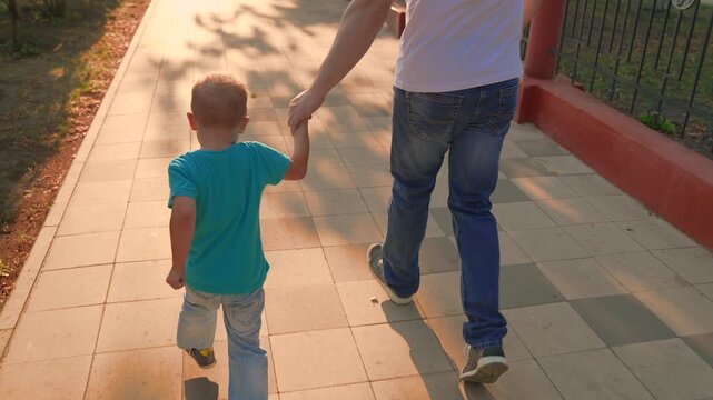 Healthy baby plays with parents in park. Happy boy child laughs runs in city park in summer. Concept of happy childhood, family. Little boy plays on street, happy emotions, laughter joy. Slow motion