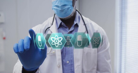 Reaching doctor wearing lab coat and mask touching medical icons in clinic room, with stethoscope