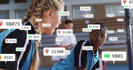 Leaning athletes wearing blue jerseys discussing strategy in school gym with analytics overlay