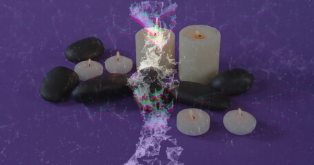 Showing white pillar candles, tealights and black stones on purple cloth with triangle mesh overlay