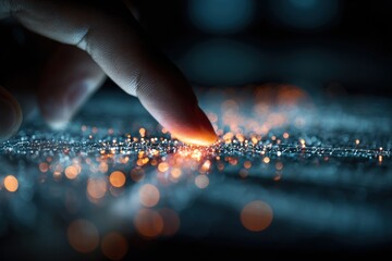 A finger touches a glowing, particle surface