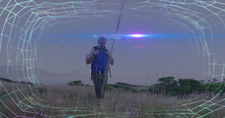Striding hiker in blue vest gripping tan backpack in windswept grassland with wireframe overlay