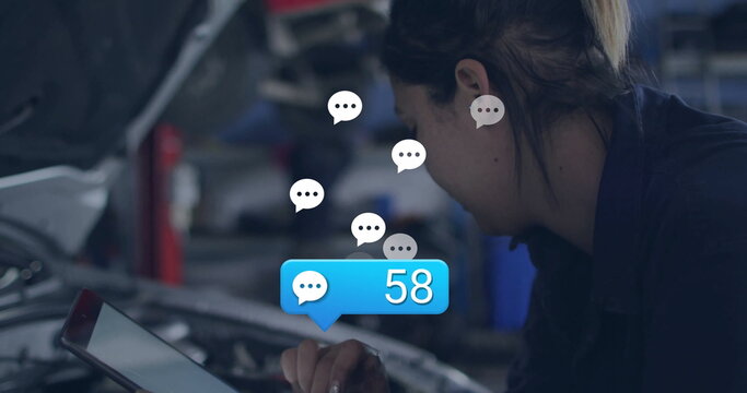 Leaning technician checking tablet under hood in garage with floating icons showing 58, copy space