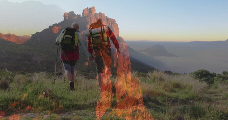 Walking hiking couple climbing mountain slope at sunrise, with backpacks, poles, boots, flames