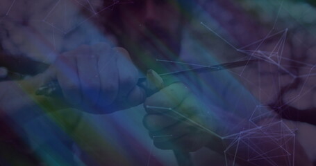 Carving jacket-sleeved hands gripping folding knife and peeling stick in forest, with network lines
