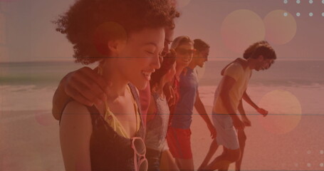 Walking seven friends in beachwear along beach shoreline at sunset, with sunglasses and lens flares
