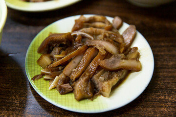 Sliced braised pork head skin arranged on a patterned plate, soy braised until tender with glossy brown surface and savory aroma