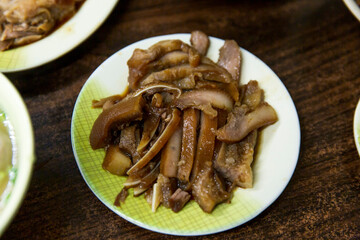 Braised pork head skin slices on a patterned plate, rich soy sauce braising giving a shiny surface and tender chewy texture
