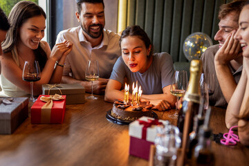 Birthday Girl Blowing Candles Surrounded by Friends