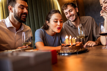 Birthday Girl Blowing Candles Surrounded by Friends