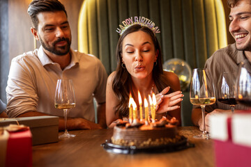 Birthday Girl Blowing Candles Surrounded by Friends