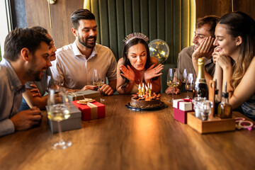 Birthday Girl Blowing Candles Surrounded by Friends