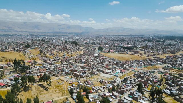 Panoramic aerial view of Huancayo and surrounding Andean plateau with vivid blue skies.