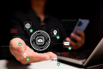 Cybersecurity and digital protection. A businessman uses a smartphone and laptop while interacting with secure data icons in a modern office, highlighting privacy, encryption, and safe online access.