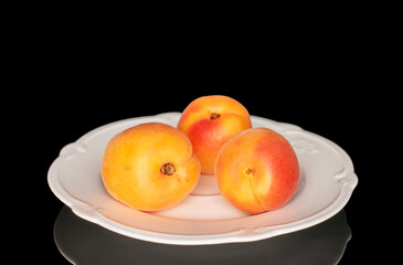 Ripe organic apricots isolated on black background, macro.