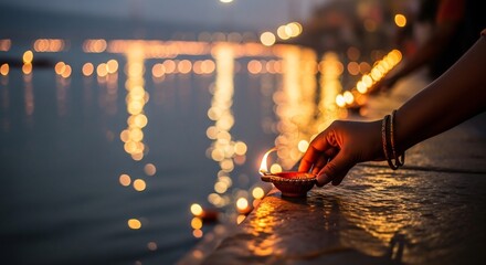 Diwali celebration scene. Hands place lit diya oil lamps on ghats by the Ganges river. Festive Hindu holiday design material, religious event promotion, spiritual concept.
