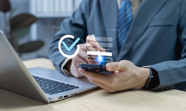Businessman verifying digital identity with tick mark and secure password on smartphone, highlighting digital security and modern authentication technology.