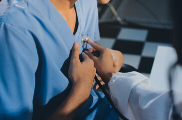 A physician uses a stethoscope to examine a patient's heart during a clinic appointment.