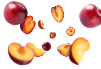 Fresh ripe plums swirling in air against white background