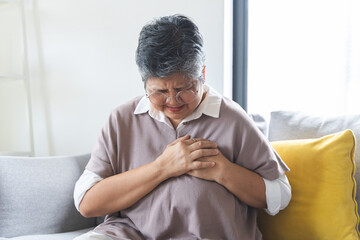 Chest pain, attack chest, emergency heartbeat asian senior woman holding hand on chest, suffering...