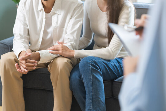 Psychology, depression asian young couple love woman and male patient consulting problem mental health with psychologist, psychiatrist at clinic together, wife encouraging husband, therapy health care