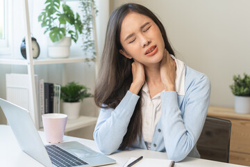 Body muscles stiff problem, ache asian young woman, girl pain neck while sitting work on chair at...