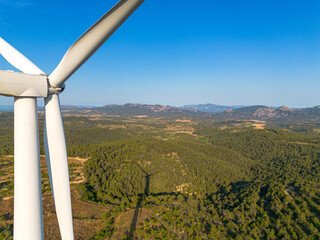 Close detail of wind turbine with mountains in background in Terra Alta, Catalonia, Spain, representing renewable energy landscape, clean technology and sustainable development goals