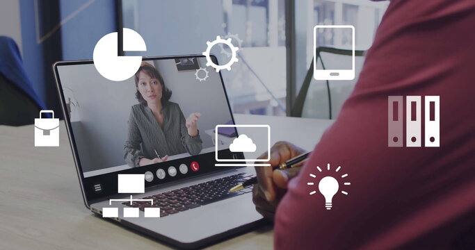 Senior man wearing burgundy sweater consulting on call at light wood office desk with laptop, icons