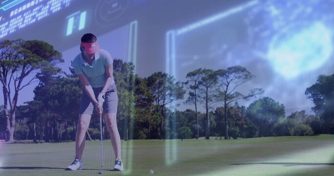Aligning female golfer wearing visor, polo shirt and golf shoes, gripping putter near ball on green
