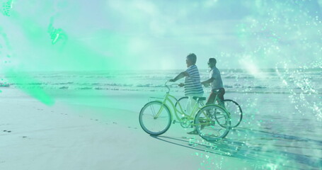Pedaling mother and son along beach shoreline with yellow cruiser dark beach cruiser and footprints