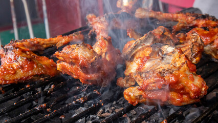 chicken meat that has been seasoned with sauce and is being grilled