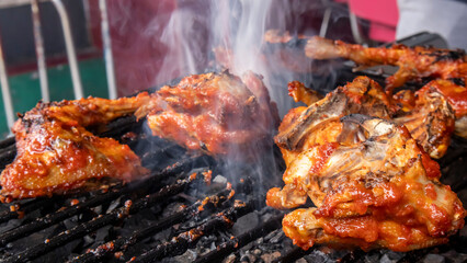 chicken meat that has been seasoned with sauce and is being grilled