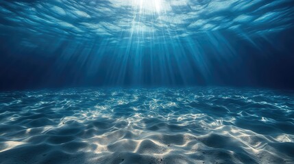 Fototapeta premium Sunlight beams pierce the deep blue ocean, illuminating the sandy bottom.