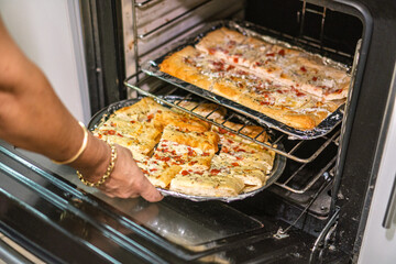 Chef taking garlic bread from oven for lunch