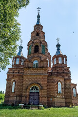 Obraz premium Historic Mykolaivska Orthodox church with distinctive brick architecture and green domes in Pustoviitivka village, Sumy region, Ukraine. Example of traditional Ukrainian religious architecture
